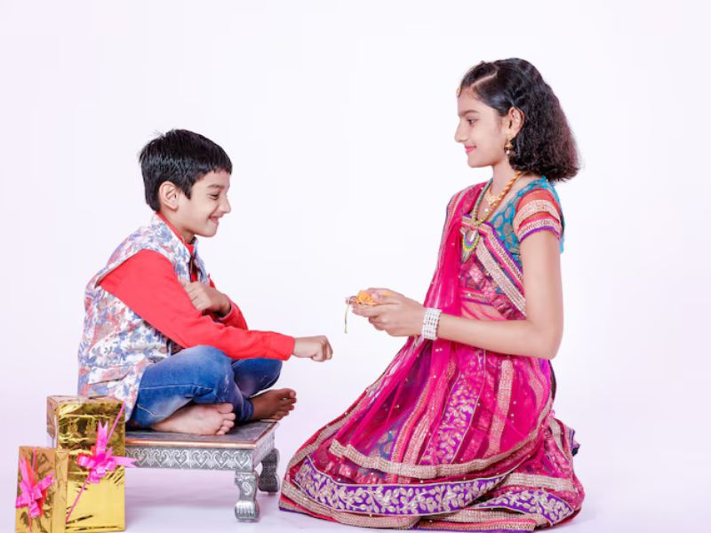 Warm Raksha Bandhan Greetings for Every Relationship Wordsmithh Blog Sister Tying Rakhi with a Greeting Card in Hand